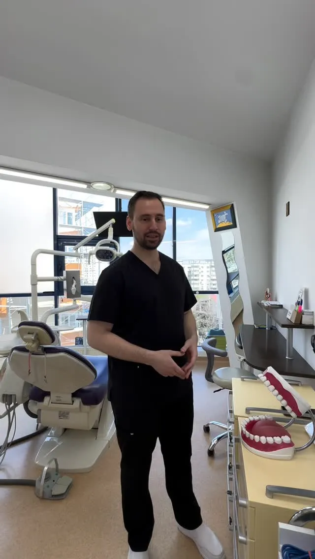 Dr. Radu Patriche în cabinet, lângă un model de arcade dentare.