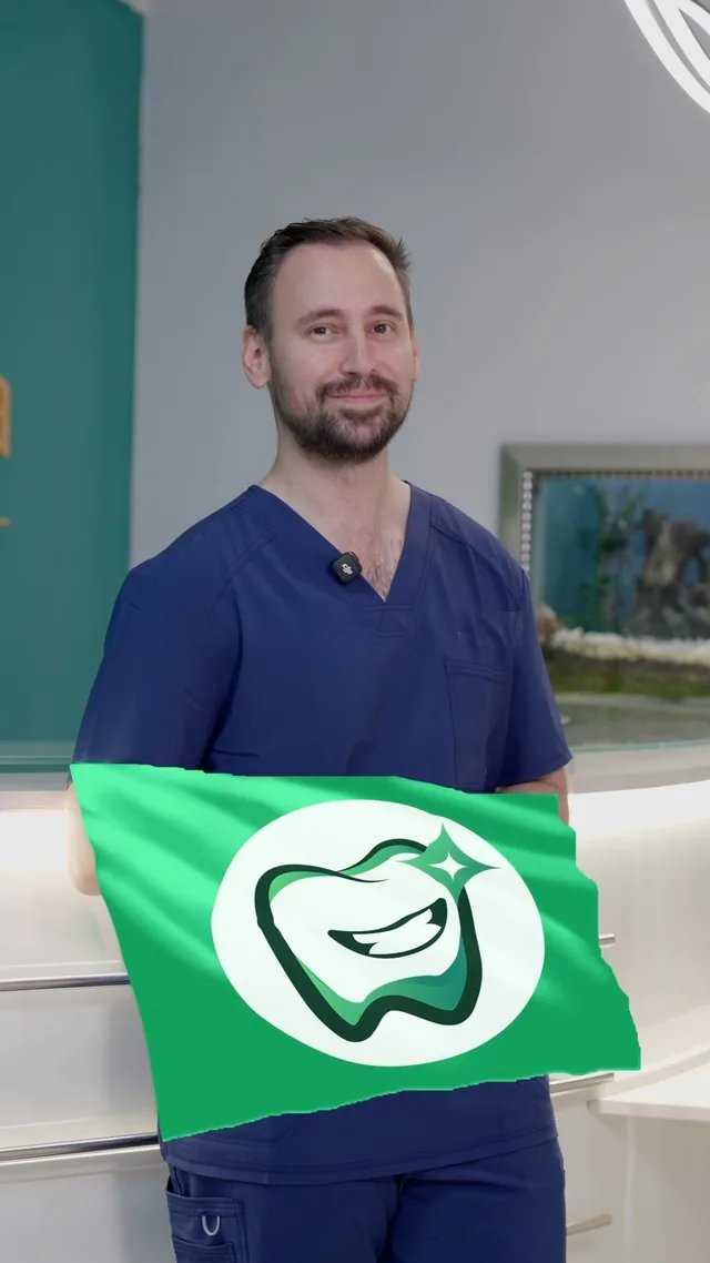 Dr. Radu Patriche ținând un steag verde cu semnul lui: un dinte care zâmbește, cu o sclipire alături.